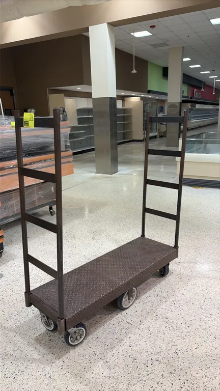 6-wheel U-boat platform cart. Features a diamond plate steel deck and dual tall tubular end handles. Mounted on 6 casters with a center tilt design.