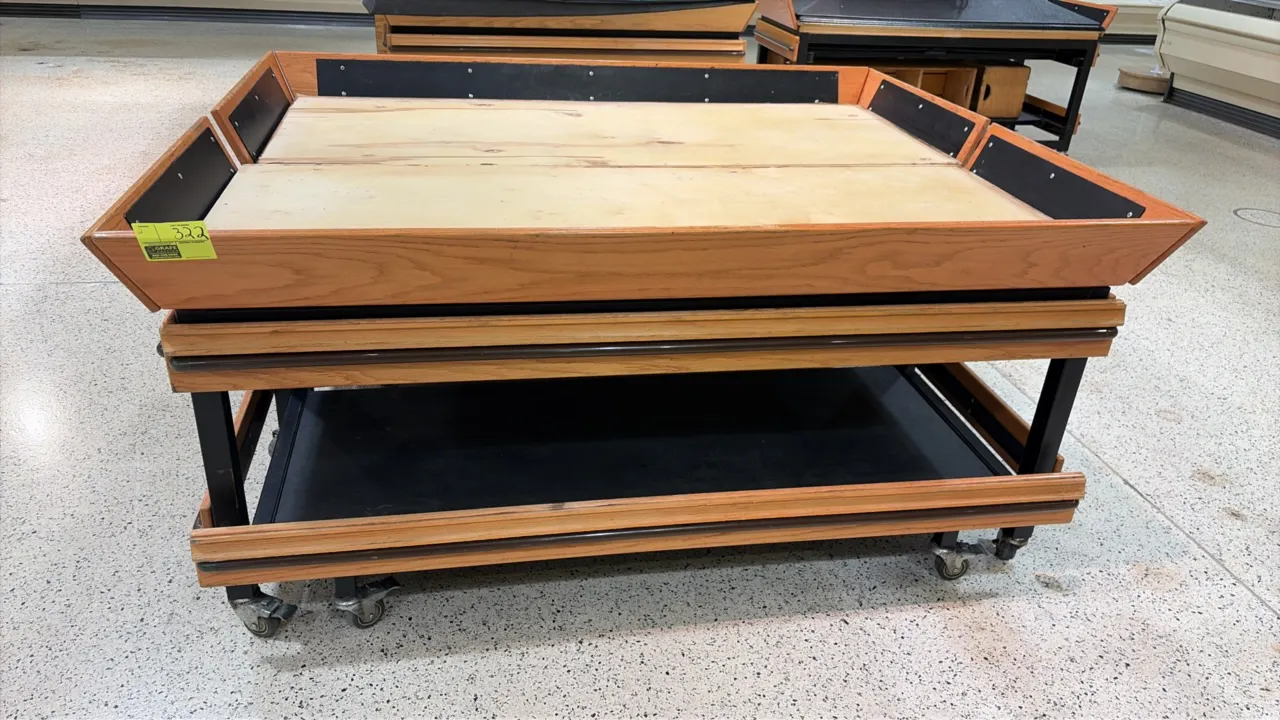 Produce display tables. Features woodgrain trim, protective bumper rails, upper display deck, and lower shelf. 6'L. Mounted on casters.