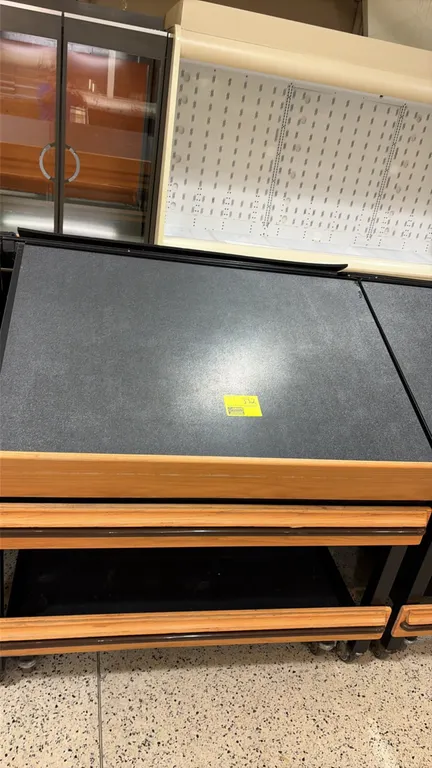 Produce tilt display tables. Features slanted display deck with textured surface mat, wood-look front retaining lip and protective bumper trim, and lo