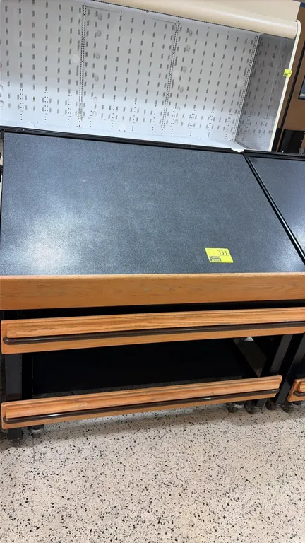Produce tilt tables. Features slanted display deck, woodgrain-finish front bumper rails, and lower storage shelf. 4'L each. Mounted on casters.