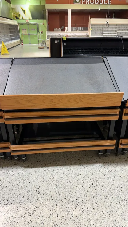 Produce tilt tables. Features slanted display deck, front woodgrain retaining lip, bumper rails, and lower storage shelf. 4'L each. Mounted on casters