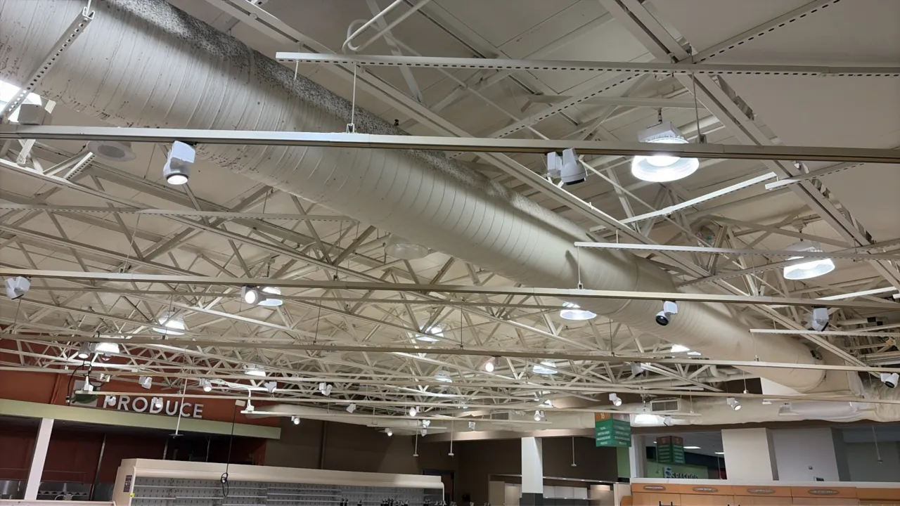 Produce area track lighting system. Includes suspended lighting tracks and adjustable white track light heads. Note: High-bay lighting fixtures, speak