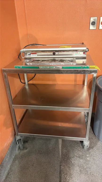 Stainless steel utility cart. Features a 3-tier design with two lower shelves. 30" x 20". Mounted on swivel casters. Note: Wrapping machine not includ