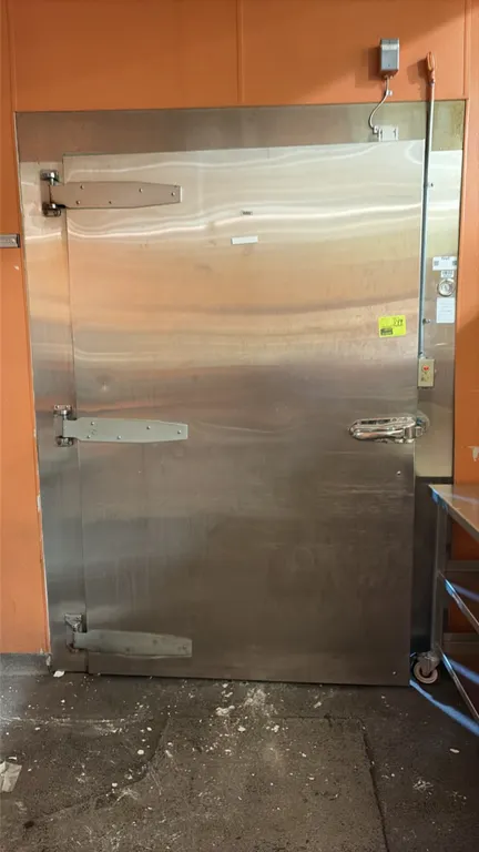 Walk-in cooler. Features a stainless steel hinged entrance door with latch handle, modular panel walls, interior overhead lighting, and (2) Larkin 2-f