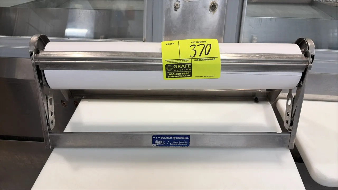 Bulman Products stainless steel roll paper cutter. Features a stainless steel frame and spring-loaded cutting blade. Includes loaded paper roll.