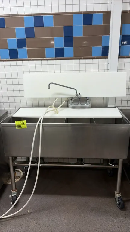 Stainless steel 3-compartment sink. Features poly cutting board surfaces, splash-mount faucet with swing spout, and lever waste drains. 48" x 24". Mou