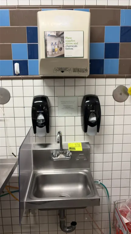 Advance Tabco stainless steel hand sink. Features a splash-mount gooseneck faucet and left side splash guard. Includes (2) wall-mount soap dispensers