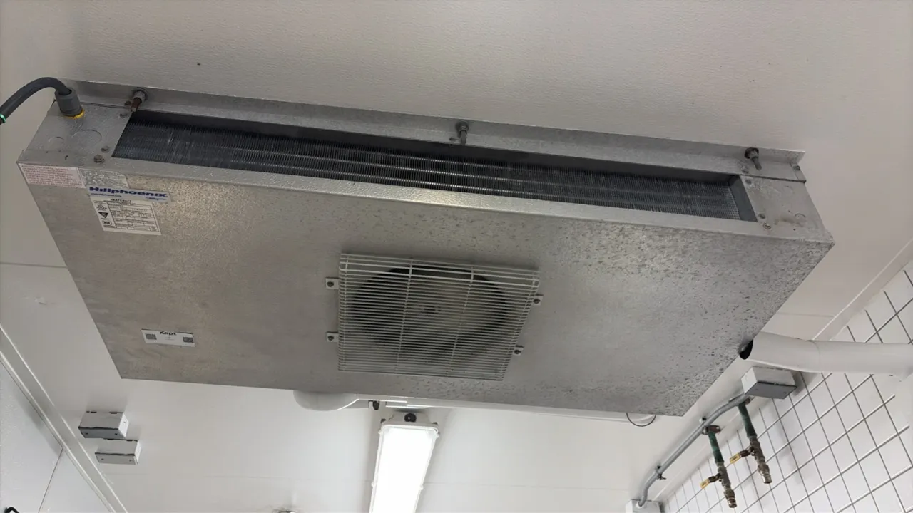 Hillphoenix single-fan evaporator coil. Features a metal casing, finned coil, and protective wire fan guard. Ceiling mounted.