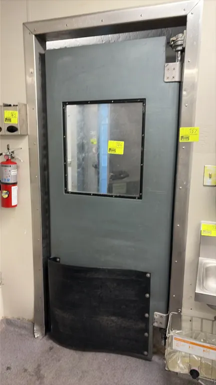 Poly swing door with frame and hinges. Features a clear vision window, lower impact bumper plate, and stainless steel frame. Dimensions: 34" x 80".