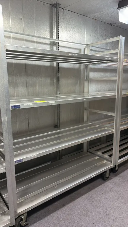 Aluminum 4-tier cart. Features channeled aluminum shelves. 5'L. Mounted on casters.