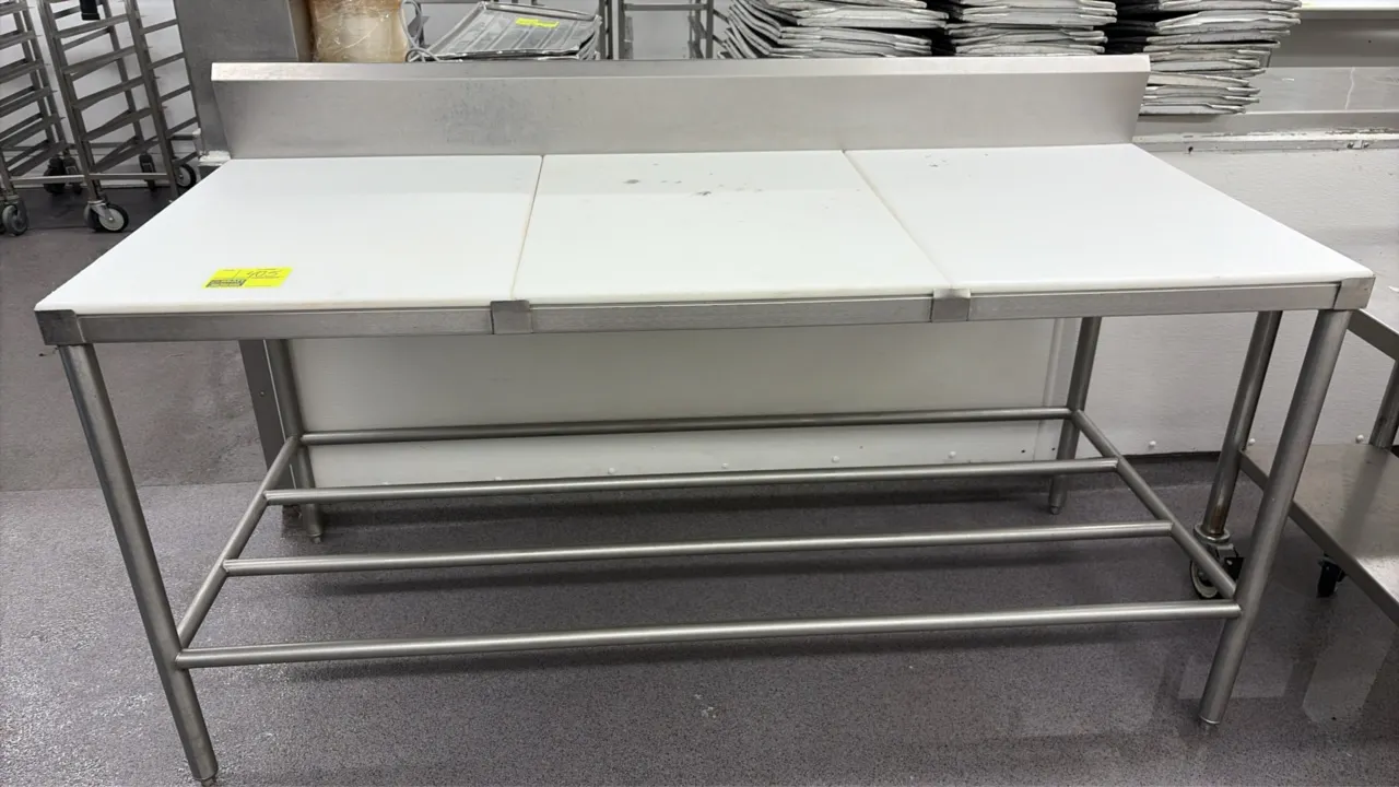 Stainless steel poly top work table. Features a 3-piece poly cutting board top, integrated backsplash, and tubular stainless steel undershelf. 72" x 3