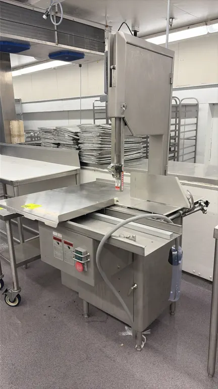 Biro 3334 meat saw. Features stainless steel construction, sliding meat carriage table, stationary table, adjustable thickness gauge plate, blade guar