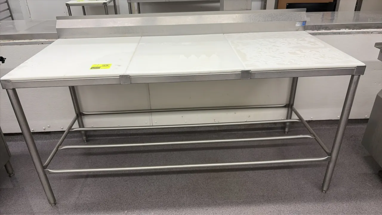 Stainless steel poly top work table. Features a 3-piece removable poly cutting board surface, integrated rear backsplash, and tubular open undershelf.