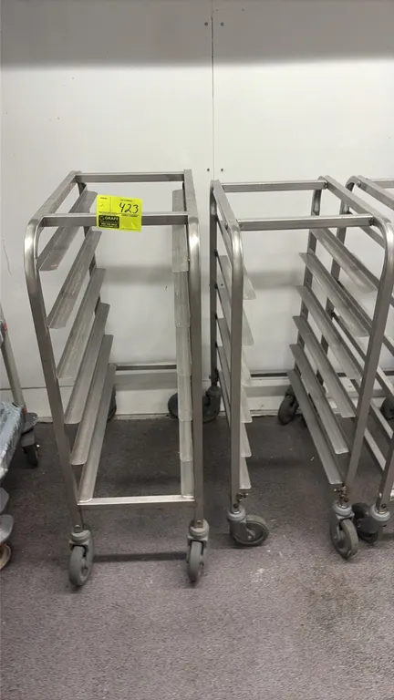 Stainless steel half-size sheet pan racks. Features 6-tier angle slides and tubular frame construction. Mounted on swivel casters.