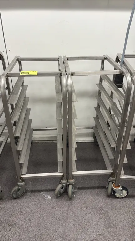 Stainless steel half-size sheet pan racks. Features 6-tier pan slides and stainless steel tubular frame construction. Mounted on swivel casters.