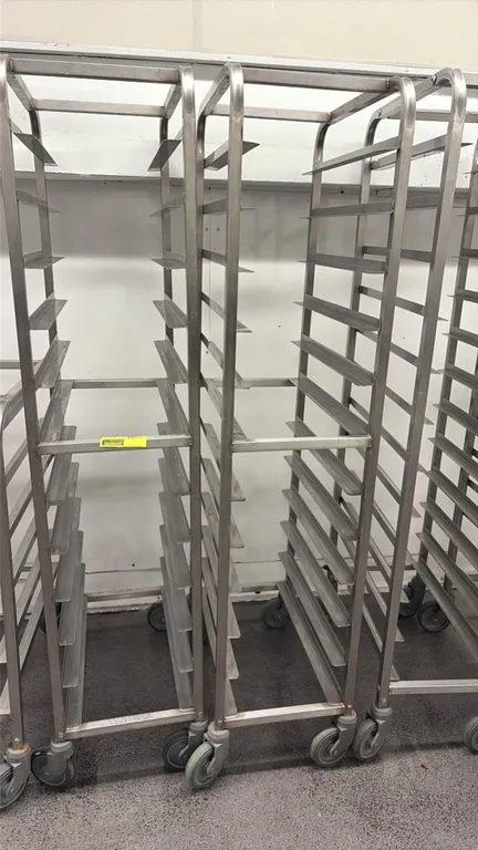 Stainless steel full-size platter racks. Features welded tubular construction with 12-tier angled slides. Mounted on swivel casters.