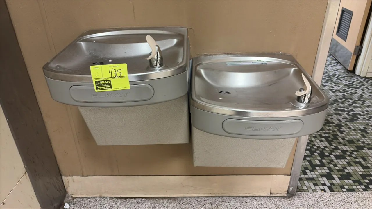 Elkay water fountains. Features stainless steel basins with front push-bar activation, bubblers, and gray vinyl-clad lower enclosures. Designed for wa
