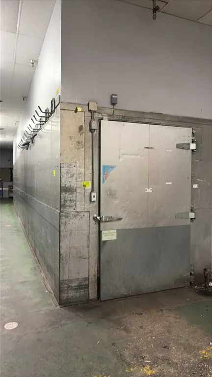 Dairy walk-in cooler. Features a single hinged entry door, interior ceiling lighting, wall bumper rails, and (3) Hillphoenix 2-fan evaporator coils. C