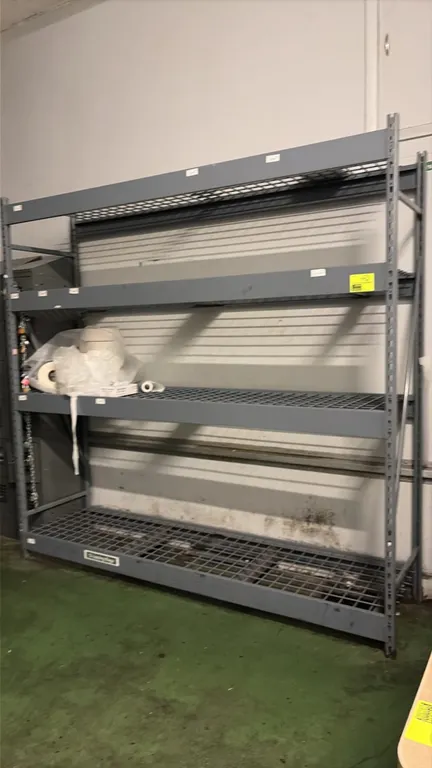 8'L of warehouse racking. Features steel frame construction with 4 levels of wire mesh decking. Dimensions: 8'L x 26"D x 8'H. Contents not included.