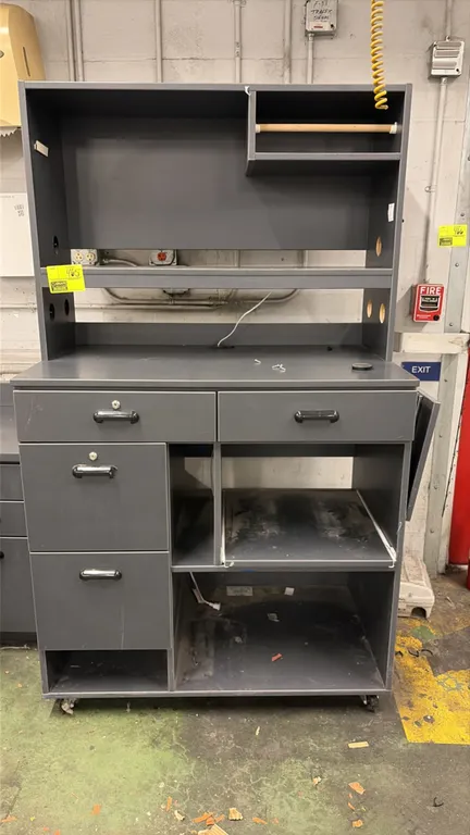 Wood laminate mobile receiving station. Features an upper hutch with paper roll holder, cord pass-through cutouts, four utility drawers, pull-out slid