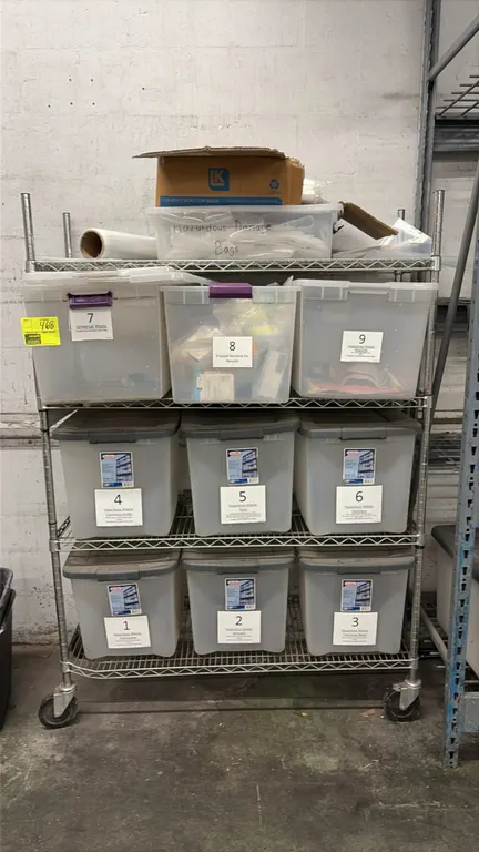Mobile chrome wire rack with plastic storage tubs. Features 4-tier wire shelving construction and assorted plastic storage tubs with lids. Mounted on