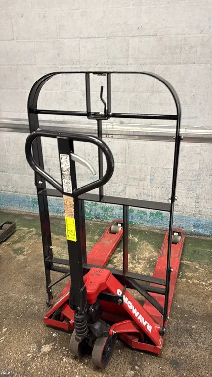 Raymond manual pallet jack. Features hydraulic hand pump operation with 3-position control lever, dual steer wheels, and an attached steel load backre