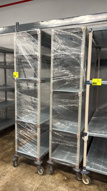 Metro MetroMax portable shelving racks. Features 5-tier polymer grid shelves and protective corner bumpers. 48"L x 18"W x 80"H. Mounted on swivel cast