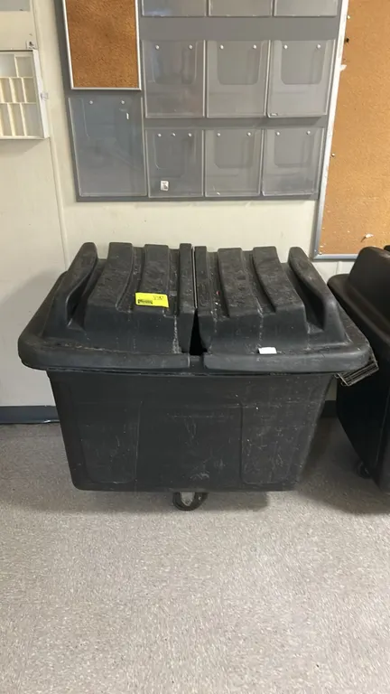 Rubbermaid poly trash cart. Features black molded polyethylene construction and a split hinged domed lid. Mounted on casters.