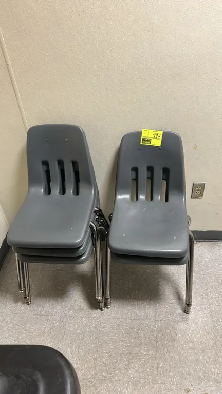 Stacking poly chairs. Features gray molded polypropylene shells with vented backs. Mounted on chrome tubular metal four-leg bases with floor glides.
