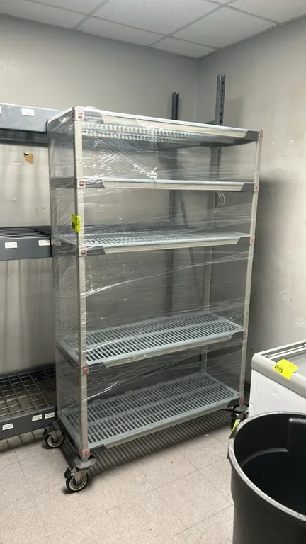 Metro MetroMax mobile multi-tier shelving rack. Features 5 slotted polymer shelf levels. 48" x 18". Mounted on swivel casters with protective bumpers.