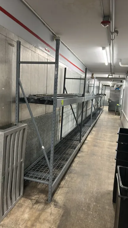 Metal multi-tier light-duty warehouse racking. Features steel upright frames, adjustable cross beams, and wire mesh decking. Dimensions: 8'L x 2'D x 8