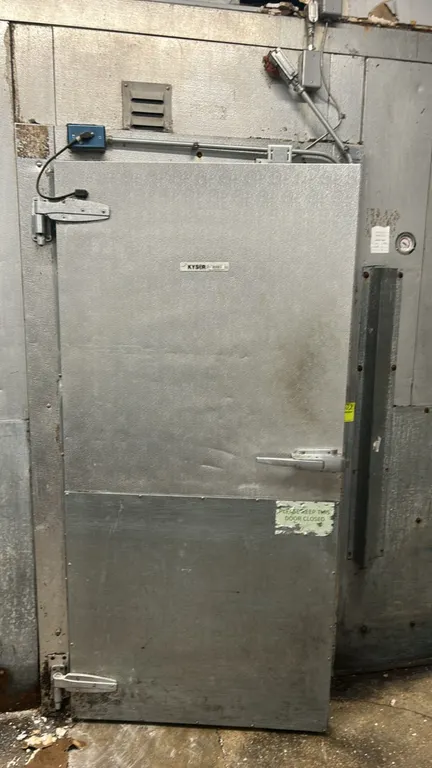 Kysor walk-in freezer. Features foam panel construction, diamond plate flooring, Larkin 3-fan evaporator coil, wall-mounted shelving, interior lightin
