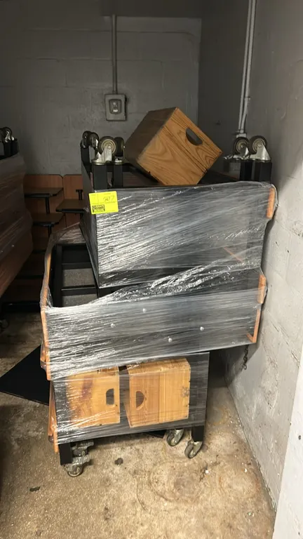 Portable metal produce dump tables. Features black metal frame construction with wood-tone trim and edge bumper guards. Includes wooden display crates
