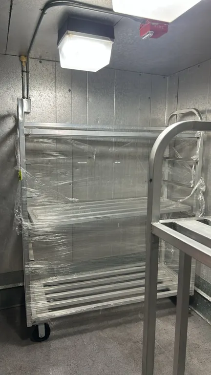 Aluminum 3-tier mobile utility cart. Features slatted aluminum shelves and integrated tubular push handle. 5'L x 2'W. Mounted on casters.