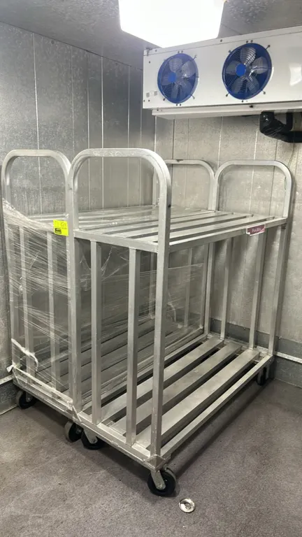 Aluminum 2-tier transport carts. Features welded aluminum construction, slatted top and bottom shelves, vertical side rails, and tubular push handles.