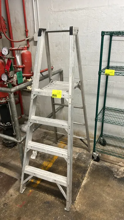 Aluminum platform step ladder. Features aluminum frame, integrated standing platform, slip-resistant grooved steps, and top guardrail. 4'H.