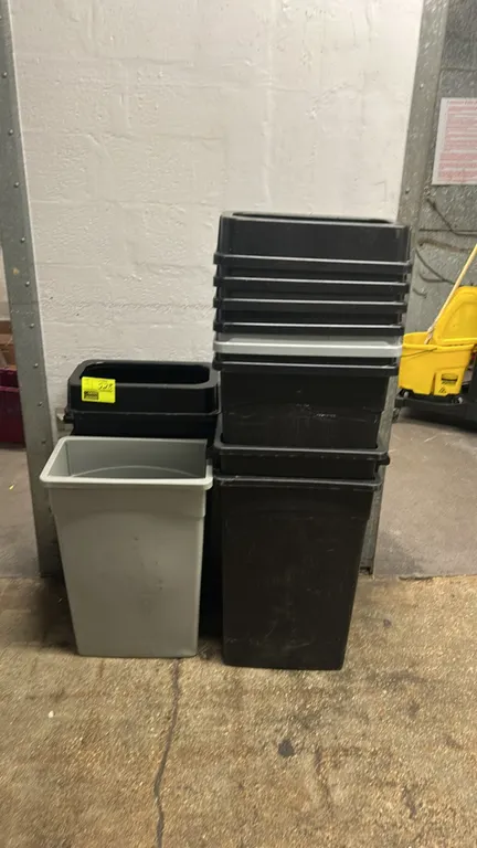 Poly slim trash bins. Includes an assortment of black and gray commercial slim plastic waste containers with drop-in open-top lids.