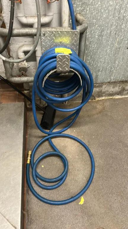 Commercial rubber water hose. Features blue rubber construction with brass hose fittings. Includes aluminum diamond-plate hose hanger.