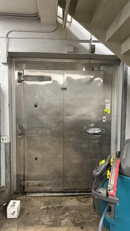 Kysor foam panel walk-in cooler. Features a pallet-sized swing door, diamond plate flooring, interior lighting, and (2) Witt 2-fan evaporator coils. D