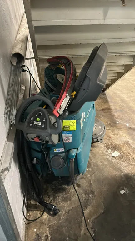 Tennant T5 walk-behind floor scrubber. Features ec-H2O technology, disk scrub deck, squeegee assembly, scrub brush, recovery tank, and rear drain hose