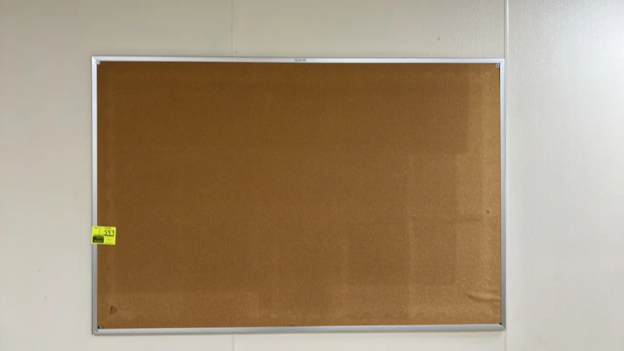 Quartet aluminum framed cork bulletin board. Features an aluminum frame with natural cork surface. 6' x 4'. Wall-mounted.