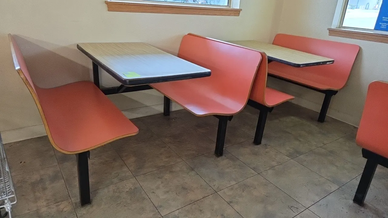 Plymold 4-passenger restaurant booth dining sets. Each set includes contoured bench seating and a woodgrain laminate tabletop. Mounted on a black meta