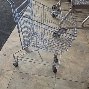 Kid-size metal shopping cart. Features wire basket construction and a red plastic handle grip. Mounted on (4) casters.