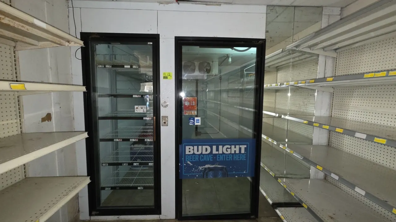 Walk-in insulated cooler. Features a 35" x 79" glass entry door, 29" x 77" reach-in glass door with feed racks, interior wall shelving, Heatcraft LSC1