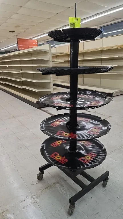Dole portable 5-tier banana display rack. Features circular tiered display levels with Dole branding and black metal construction. Mounted on a mobile