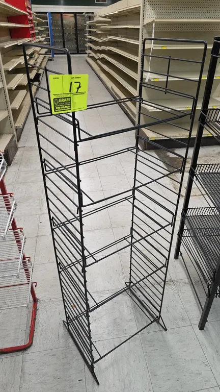 Metal merchandiser display rack. Features black wire construction with multi-tier adjustable shelf positions and a freestanding base. Dimensions: 17"W