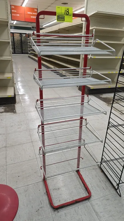 Metal 5-tier merchandiser display rack. Features a red tubular metal frame with (5) white wire display shelves. Freestanding floor base design.