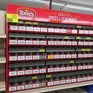 Tone's metal spices and seasoning display rack. Features 5 tiered rows with product organizer channels, individual spice labels, and branded red top m