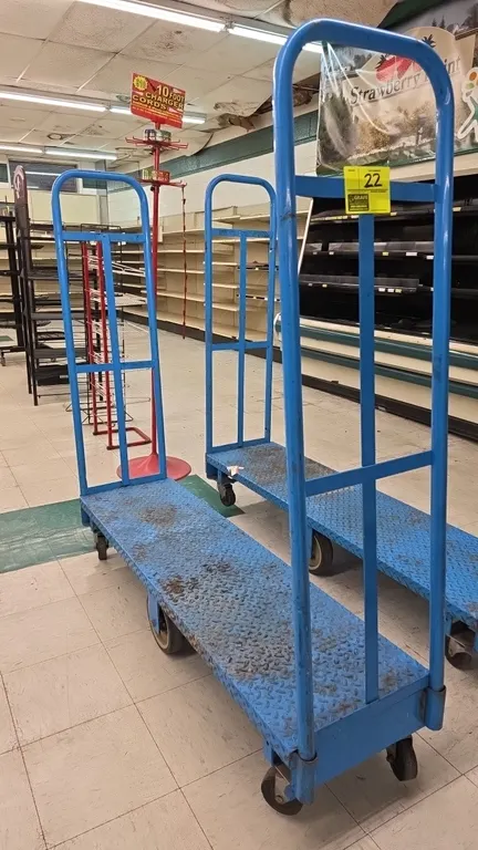 Metal 6-wheel U-boat platform cart. Features a blue diamond plate deck and tall tubular steel end handles. 60"L. Mounted on (6) wheels with rigid cent