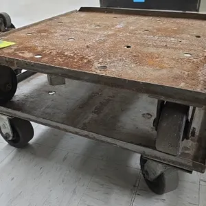 Metal 4-wheel platform dollies. Features steel construction with upturned lip edges and perforated decks. 27" x 27". Mounted on (4) casters. Note: Exh